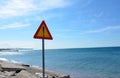 Danger road sign near ocean in summer Royalty Free Stock Photo