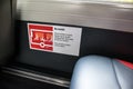 Danger safety information sign inside interior of public transport bus warning passengers