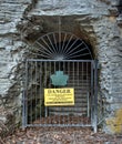 Danger sign and iron gate blocking nature trail