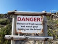 Danger sign says Beware of freak waves and watch your footing on the island Robberg Beach,