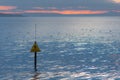 Danger Sinking Mud sign in front of sea and sunset