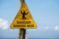 Danger Sinking Mud on a yellow beach sign