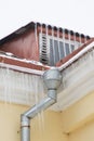 Danger of spring melting of ice: Many icicles of different sizes on the roof, gable and gutter of a residential building Royalty Free Stock Photo
