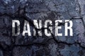 Danger text written with broken cement wall, Danger word on street