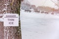 Danger, thin ice inscription on sign attached to tree Royalty Free Stock Photo