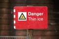 Danger thin ice safety sign at lake in winter Royalty Free Stock Photo