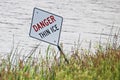 A danger thin ice sign along the shore in summer Royalty Free Stock Photo