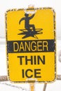 Danger Thin Ice yellow sign of warning people careful this area and have hoarfrost stick on it, in winter season at Regina Royalty Free Stock Photo