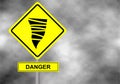 Danger tornado road sign . Yellow hazard warning sign against grey sky Royalty Free Stock Photo