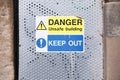 Danger unstable building keep out sign on door entrance