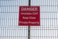 Danger, unstable cliff, keep clear, private property sign on a fence Royalty Free Stock Photo