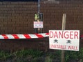 Danger unstable wall sign beside a boundary wall