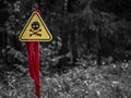 a danger zone sign in the forest next to the road, warning that the area is mined. Wartime concept. gray background Royalty Free Stock Photo
