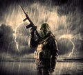 Dangerous armed terrorist with mask and gun in a thunderstorm wi