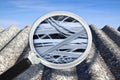 Dangerous asbestos roof with airborne fibers seen through a magnifying glass