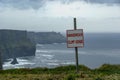 Dangerous Cliff Edge Sign In Overcast Weather At Cliffs Of Moher In Ireland. Danger Sign Warning.