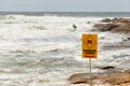 Dangerous current sign for swimmers at the beach in Australia. Lonely surfer entering the waters