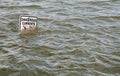 'Dangerous Currents' sign in flooded river