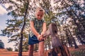 Dangerous and formidable girl chopping wood with an ax and looking angrily into the camera