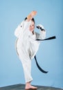 She is dangerous. Girl little child in white kimono with belt. Karate fighter ready to fight. Karate sport concept. Self