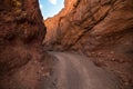 Dangerous gravel road between mountain rock in scenic desert.