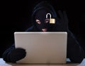 Dangerous hacker man with computer and lock hacking system in cyber crime concept