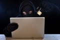 Dangerous hacker man with computer and lock hacking system in cyber crime concept Royalty Free Stock Photo