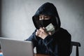 Dangerous Hooded Hacker held the money Royalty Free Stock Photo