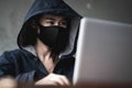 Dangerous Hooded Hacker using computers and infected virus ransomware to hacking a personal and financial data