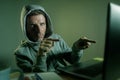 Dangerous looking hacker man in hoodie hacking internet computer Royalty Free Stock Photo