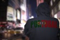 Dangerous man standing on a city street with black hoodie with text portugal on his back