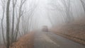 Dangerous mountain fog road. A mystical car ride through a misty forest or Park. Autumn or winter in the mountains Royalty Free Stock Photo