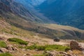 Dangerous mountain gravel road with off-road UAZ descending in mountain valley. Summer road trip, journey. Way to Burkhan-Bulak