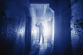 Dangerous Murderer or killer with Knife in hand and light from back in scary corridor in Phantom Blue color toned