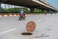 Dangerous opened manhole hole cover, opened sewerage hatch with traffic on background Royalty Free Stock Photo