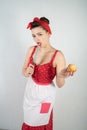 Dangerous pin up girl housewife in red vintage polka dot dress stands with a huge kitchen knife in her hands and angrily rejoices