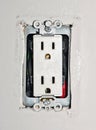 Dangerous power outlet with exposed wires without the plastic wall plate safety cover.