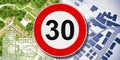From dangerous road for cars to safe road for people - concept with zone 30 road sign, imaginary city map, residential buildings Royalty Free Stock Photo