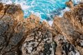Dangerous rocky sea shore with azure water, aerial drone top view.