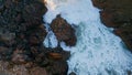 Dangerous rocky sea shore with stormy foaming water crashing stones aerial view.