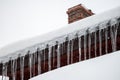 Dangerous sharp icicles and snow hanging from the roof