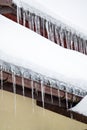 Dangerous sharp icicles and snow hanging from the roof