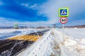 Dangerous snowing road with crosswalk, bus stop and road signs for driving cars and public transport during blizzard Royalty Free Stock Photo