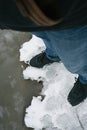 Dangerous thin ice. Man takes risk to step on frozen river surface in winter. Caution. unsafe water