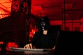 Dangerous unrecognizable hacker man wearing in black mask and sweatshirt hacking online web site using laptop and