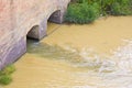 Dangerous, untreated, toxic polluted water flows from a city sewer to the river