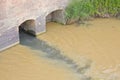 Dangerous, untreated, toxic polluted water flows from a city sewer to the river