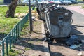 Dangerous waste material dumped on the urban city street near garbage cans polluting and littering environment with hazard junk wa