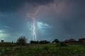 Forked lightning strikes in a rural landscape