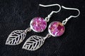 Dangle earrings made of epoxy resin and dried rose petals Royalty Free Stock Photo